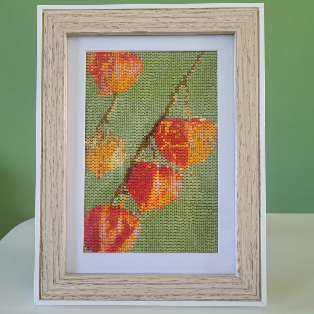 Ingelijst kralenschilderij van lampionbloemen in herfstkleuren